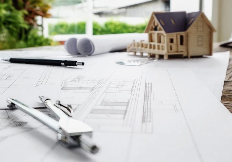 Plans de construction avec un maquette de maison en bois et des outils d'architecture.